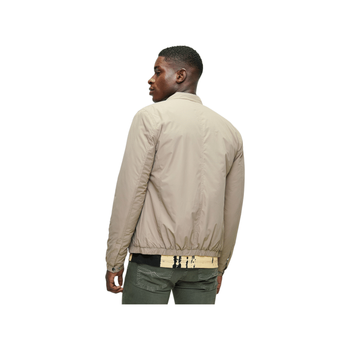 702 24A | The Polo Jackets Men's LS Tech Puffer Harrington in Taupe combines classic style with modern functionality. Featuring a lightweight, insulated design and a water-resistant outer shell, this jacket offers warmth and protection while maintaining a sleek, sophisticated look.