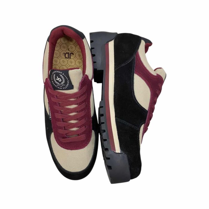 55 112B | The Jonathan D Sneaker in Jimmy Dusk Maroon/Black combines bold style and comfort, featuring a high-quality synthetic and suede upper in a striking maroon and black colorway that adds sophistication to any outfit. Its cushioned insole and breathable lining ensure all-day comfort, while the durable rubber outsole provides excellent traction and stability on various surfaces. With its sleek design and subtle stitching details, this sneaker transitions effortlessly from casual wear to more polished looks, making it a versatile and stylish addition to any modern wardrobe.