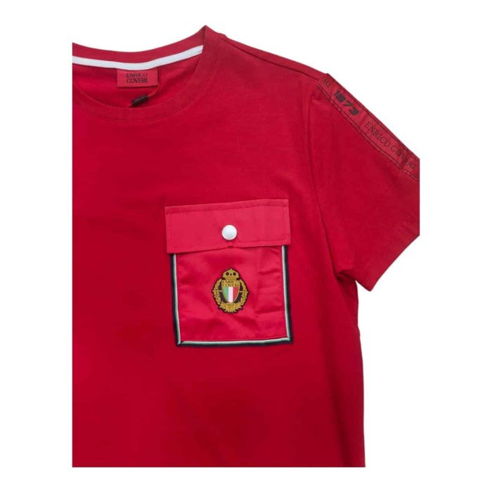 559 108 B 1 rotated | The Enrico Coveri T-shirt with Button Pocket Logo in Red is a striking and stylish addition to any wardrobe, featuring a vibrant red hue that instantly draws attention and adds a bold pop of color to your outfit. Crafted from soft, breathable fabric, this T-shirt not only provides exceptional comfort for all-day wear but also incorporates a functional buttoned pocket on the chest, enhancing its design with practicality while showcasing Enrico Coveri’s signature attention to detail. With a relaxed fit and the iconic logo subtly placed near the pocket, this T-shirt effortlessly combines modern aesthetics and timeless appeal, making it a versatile piece that pairs beautifully with jeans, shorts, or layered under a jacket for a polished yet casual look.