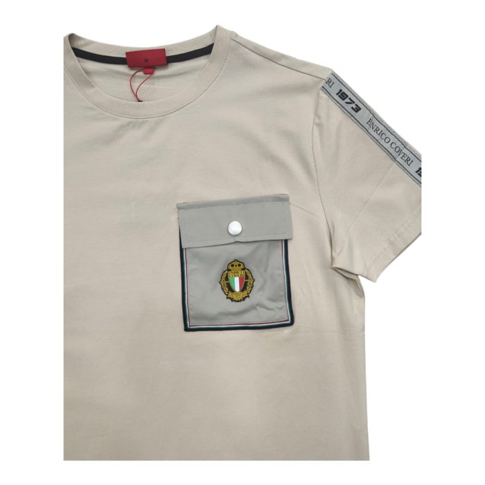 559 111 C | The Enrico Coveri T-shirt with Button Pocket Logo in Khaki combines understated style with thoughtful functionality, making it a versatile choice for any casual or semi-formal occasion. Its soft, breathable fabric and classic khaki color create a comfortable yet polished look, enhanced by a stylish buttoned chest pocket that serves as both a functional detail and a focal point. With the Enrico Coveri logo subtly placed near the pocket, this T-shirt reflects the brand’s dedication to quality and craftsmanship, offering a relaxed fit that effortlessly complements a range of outfits, from jeans to chinos.