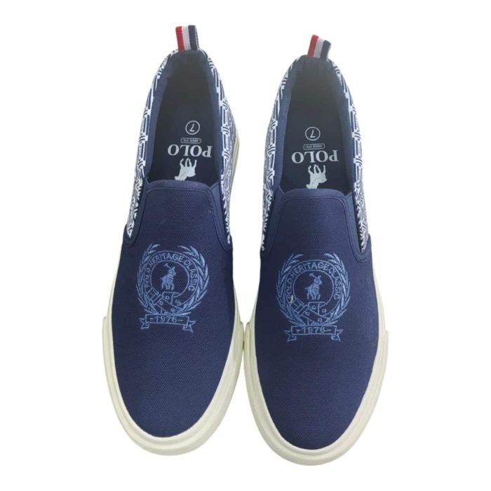 400 5 B | The Polo AOP Crest Slip-On Navy seamlessly blends classic style with modern convenience, featuring an all-over crest pattern that exudes sophistication against a rich navy backdrop. Crafted from high-quality canvas, these slip-ons are not only lightweight and breathable but also designed with a cushioned insole to ensure all-day comfort, making them perfect for casual outings or relaxed gatherings. With their easy slip-on design and durable outsole for reliable traction, the Polo AOP Crest Slip-On Navy is an ideal choice for anyone seeking a versatile and stylish footwear option that effortlessly complements a variety of outfits.