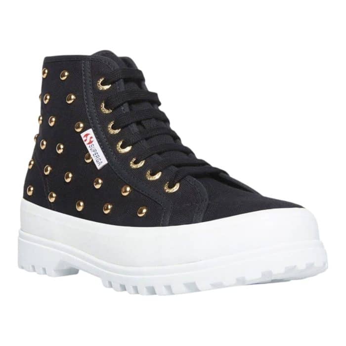 556 7 B | The Superga 2341 HI Top Alpina Studs in Black/Gold combines bold style with durable functionality, featuring a sleek black canvas upper adorned with striking gold-tone studs for a rebellious yet sophisticated look. Its chunky lug sole provides exceptional grip and stability, making it perfect for both urban adventures and rugged terrains, while the high-top design ensures added ankle support and comfort. With its edgy aesthetic, premium craftsmanship, and versatile appeal, this statement sneaker effortlessly elevates any casual outfit with a touch of glamour and attitude.