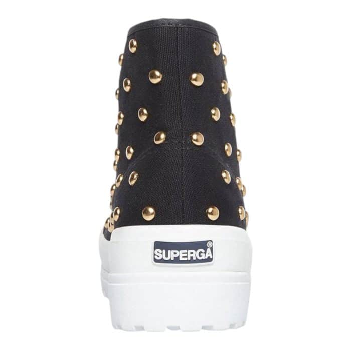 556 7 D | The Superga 2341 HI Top Alpina Studs in Black/Gold combines bold style with durable functionality, featuring a sleek black canvas upper adorned with striking gold-tone studs for a rebellious yet sophisticated look. Its chunky lug sole provides exceptional grip and stability, making it perfect for both urban adventures and rugged terrains, while the high-top design ensures added ankle support and comfort. With its edgy aesthetic, premium craftsmanship, and versatile appeal, this statement sneaker effortlessly elevates any casual outfit with a touch of glamour and attitude.