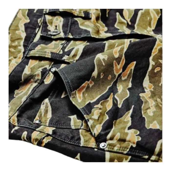 1089 3 B | The G-Star RAW 5622 3D Tapered Tiger Camo Chinos redefine modern streetwear with their bold camouflage print, ergonomic 3D construction, and tapered silhouette, ensuring a sleek yet highly functional fit that moves effortlessly with the wearer. Crafted from durable 100% cotton canvas, these chinos provide a structured yet comfortable feel, making them versatile enough for both casual and semi-formal occasions while maintaining breathability and year-round wearability. Designed with shaped knees, a secure button closure, and practical pockets, this statement piece merges G-Star RAW’s innovative tailoring with rugged military-inspired aesthetics, delivering a unique blend of style, durability, and everyday practicality.