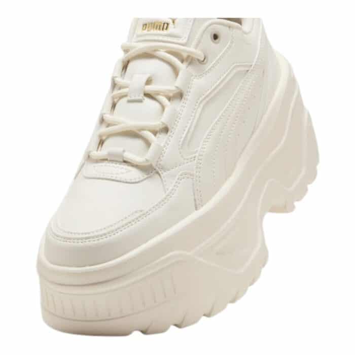 334 93 C | The Puma Karmen X-TRA in Frosted Ivory is a stylish yet functional sneaker that blends modern design with classic elements, featuring a premium leather upper complemented by synthetic overlays for durability and a sleek aesthetic. Its cushioned insole, padded collar, and lace-up closure ensure all-day comfort and a secure fit, while the platform rubber outsole provides excellent traction and a subtle height boost, making it ideal for both casual wear and urban adventures. Designed with versatility in mind, this minimalist sneaker seamlessly pairs with various outfits, offering a sophisticated touch to any wardrobe while aligning with Puma’s commitment to sustainability and high-quality craftsmanship.