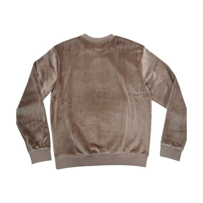 49 14 A | The Jonathan D Marti Velour Sweat Top in Taupe offers a luxurious blend of comfort and sophistication, crafted from premium velour fabric that provides a soft, plush texture with a subtle sheen, ensuring both warmth and elegance in any setting. Designed with a modern yet timeless silhouette, this sweat top features ribbed cuffs and hem for a structured fit, a classic crew neckline for versatile styling, and a neutral taupe hue that effortlessly complements various wardrobe choices. Whether paired with jeans for a casual outing or layered over a collared shirt for a refined look, this high-quality piece embodies both style and practicality, making it a must-have addition to any contemporary wardrobe