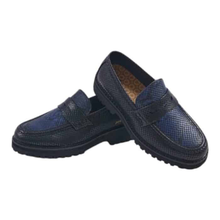 55 121 B | The Jonathan D Penny Moc Snake Eclipse in Black/Blue is a sophisticated yet contemporary loafer, designed with a high-quality PU upper that mimics the sleek appearance of genuine leather while ensuring durability and long-lasting wear. Featuring a striking black and blue color combination, this shoe seamlessly blends classic penny loafer elements—such as moccasin-style stitching and a contrast band across the vamp—with modern details like the iconic golden JONATHAN D branding at the back, making it an effortlessly stylish choice for both formal and casual occasions. With a cushioned footbed for superior comfort, a breathable interior lining to keep your feet cool, and a thick rubberized sole for excellent grip and support, this loafer not only elevates your style but also provides all-day comfort and stability for any setting.